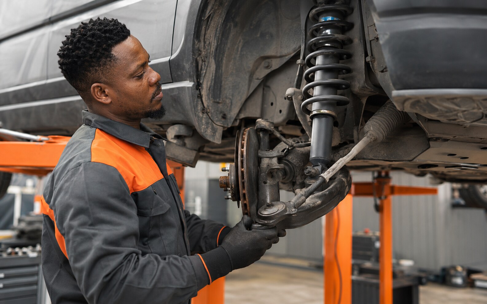 Technician inspecting and replacing vehicle suspension components